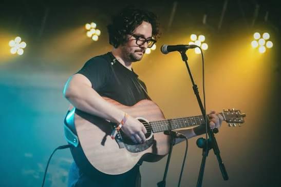 Daniel B playing guitar while performing