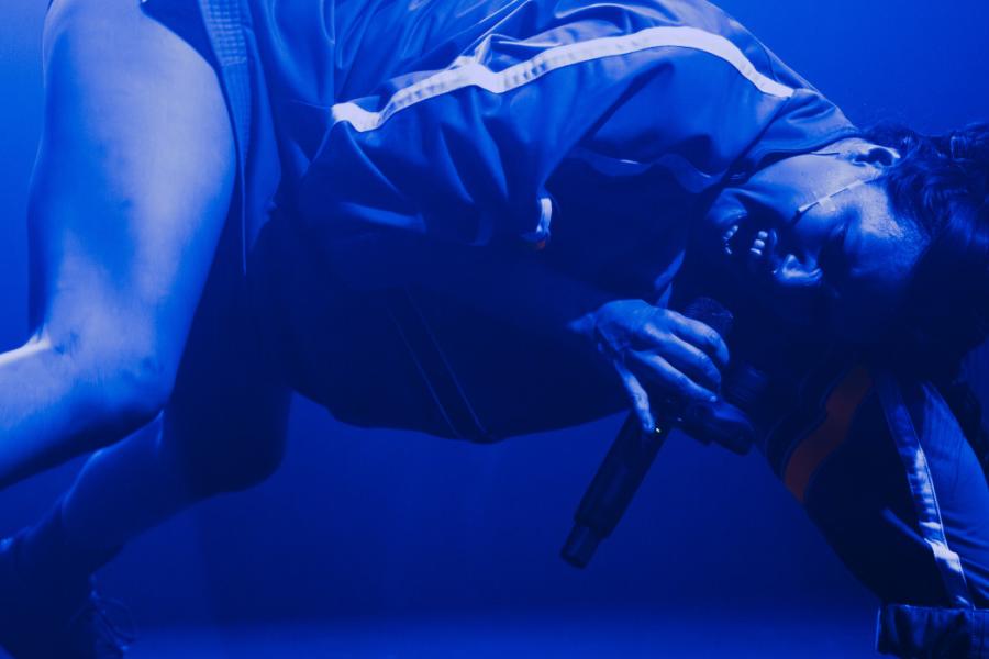 Baby Volcano dancing on stage in blue light
